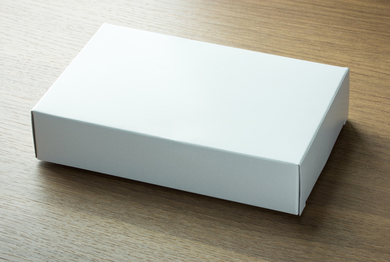 Caja de papel caple blanco sobre superficie oscura